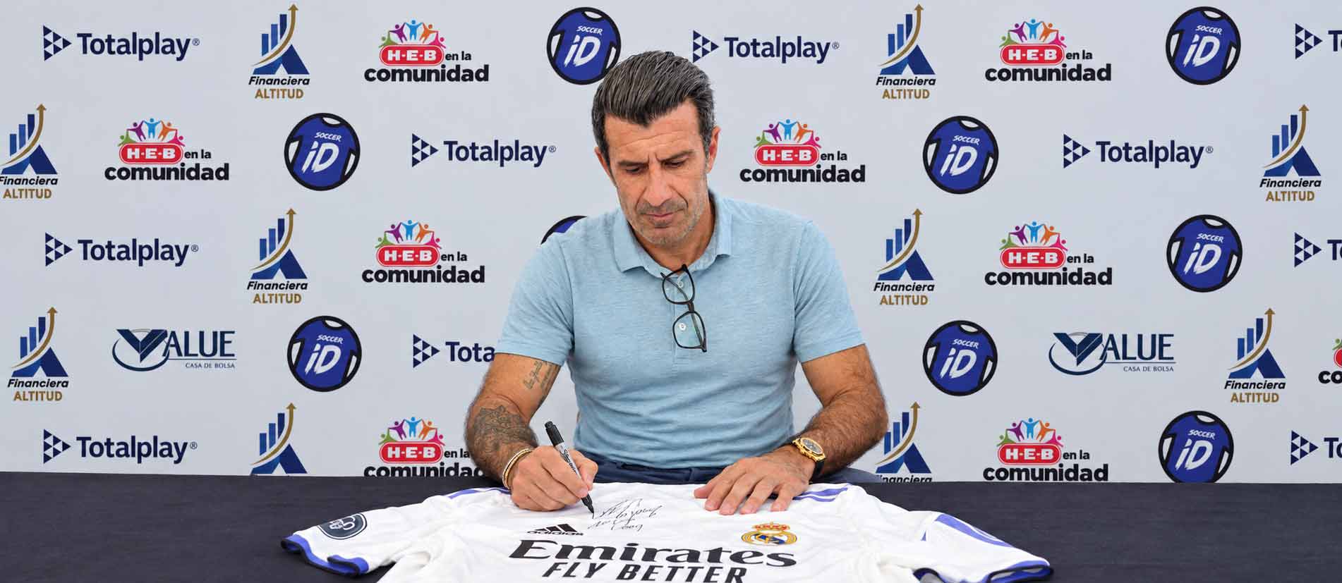 Luis Figo firma una playera en un evento de SOCCER iD Legends